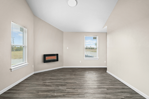 an empty living room with wood flooring and a window